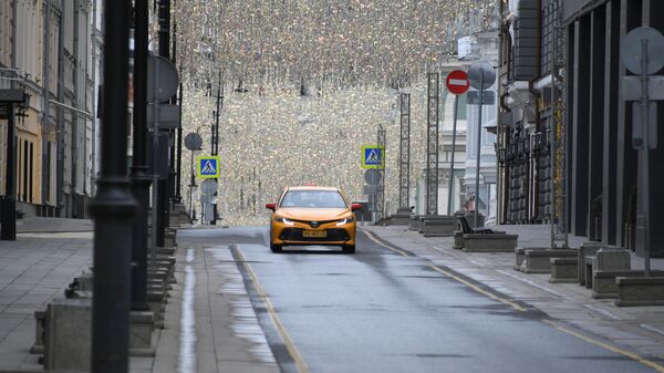 Такси едет по Столешникову переулку в Москве