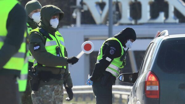 Полицейский в маске на блокпосту возле Вильнюса в Латвии