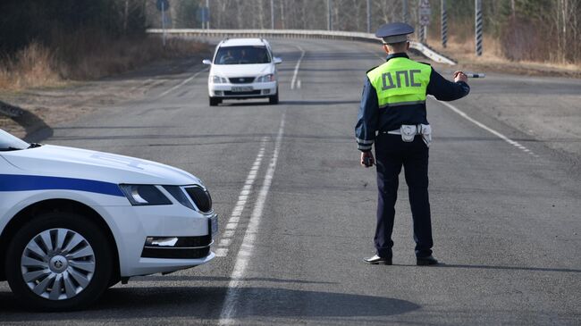 Сотрудник дорожно-патрульной службы ГИБДД на блокпосту при въезде на городское кладбище города Читы