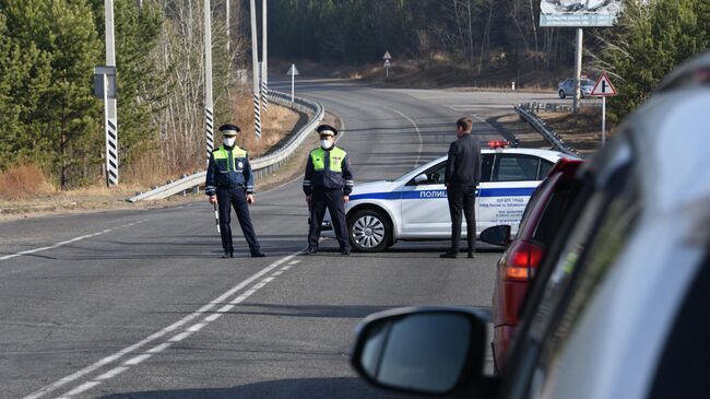 Сотрудники дорожно-патрульной службы ГИБДД на блокпосту при въезде на городское кладбище города Читы