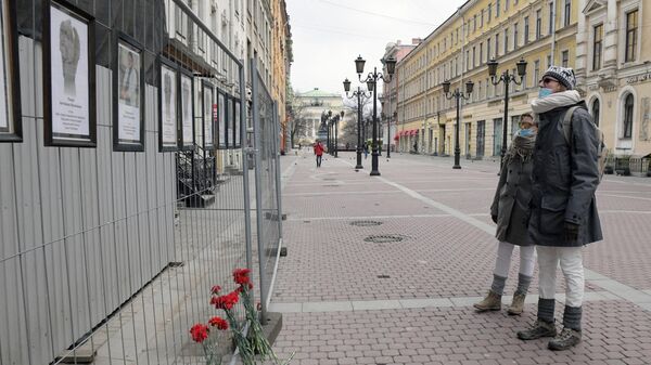 Прохожие у стены памяти умершим от коронавируса медикам в Санкт-Петербурге
