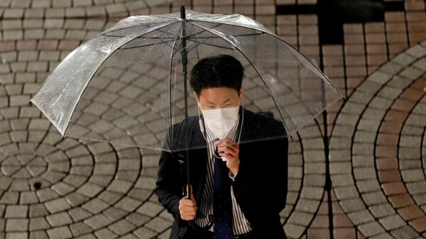 Мужчина в защитной маске в Токио, Япония