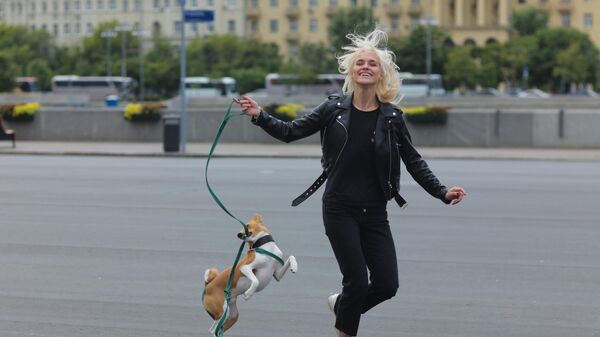 Девушка гуляет с собакой в Центральном парке культуры и отдыха имени Горького в Москве