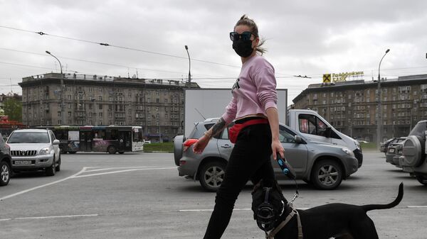Девушка в защитной маске с собакой на улице Новосибирска
