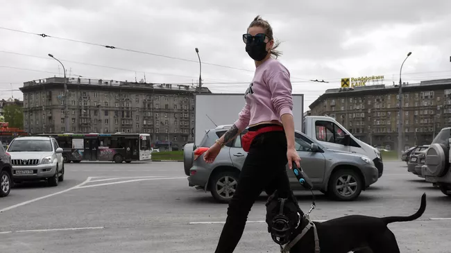 Девушка в защитной маске с собакой