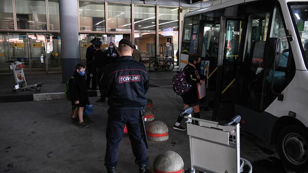 Сотрудники полиции контролируют посадку пассажиров, прибывших рейсом SU 103 компании Аэрофлот из Нью-Йорка в аэропорту Шереметьево