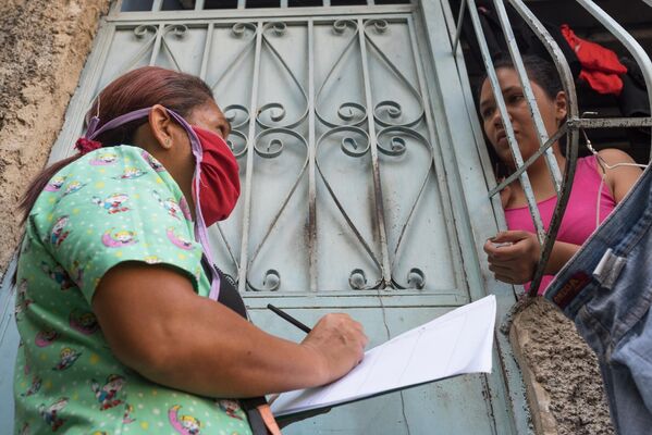 Медицинский работник во время обхода жителей для выявления случаев заболевания коронавирусом в фавелах Каракаса