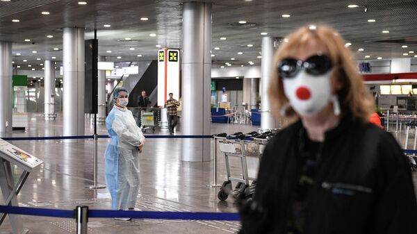 Сотрудница в защитном костюме в терминале F Международного аэропорта Шереметьево 