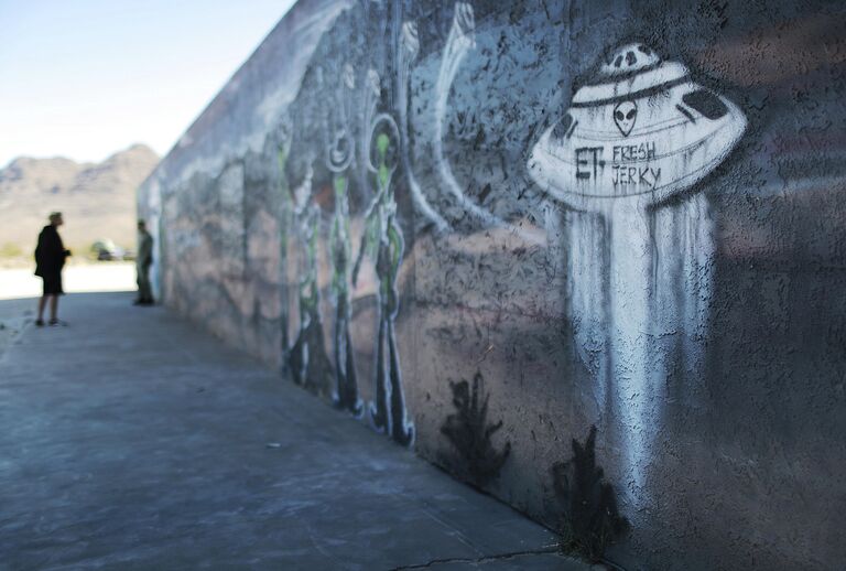 Люди около настенной росписи перед Штурмом Зоны 51 в штате Невада. 20 сентября 2019 Люди около настенной росписи перед Штурмом Зоны 51 в штате Невада. 20 сентября 2019