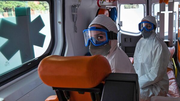 Медицинские работники в защитных костюмах в автомобиле скорой помощи в Азербайджане