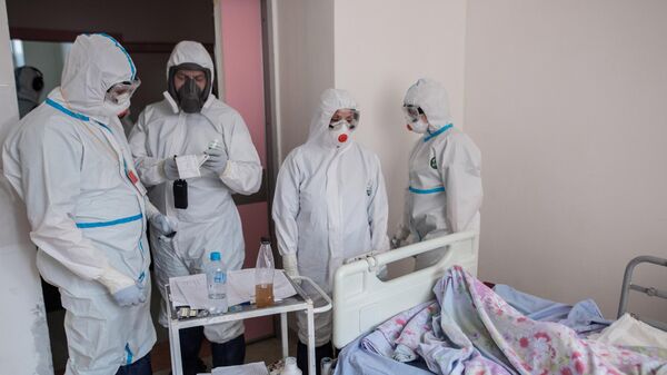 Пациент и медицинские работники в отделении реанимации и интенсивной терапии в стационаре для больных с коронавирусной инфекцией