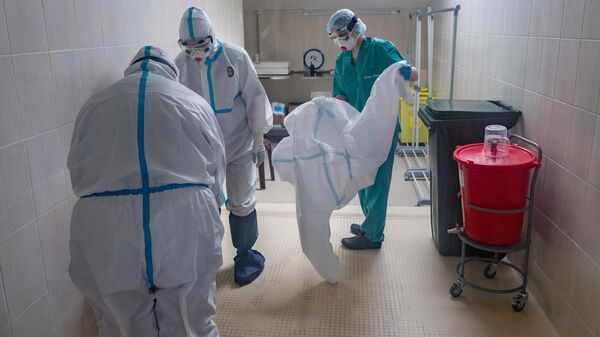 Медицинские работники одевают защитные костюмы и маски в стационаре для больных с коронавирусной инфекцией 