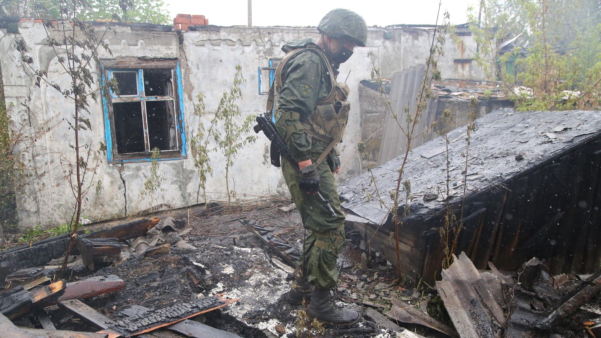 Военнослужащий НМ ДНР осматривает сгоревший дом в поселке Шахты 6-7 в Горловке - РИА Новости, 1920, 30.09.2020