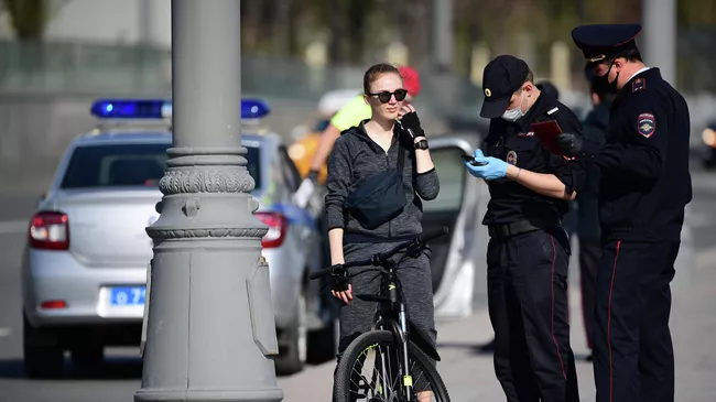 Сотрудники полиции проверяют документы у девушки на велосипеде на Москворецкой набережной в Москве.