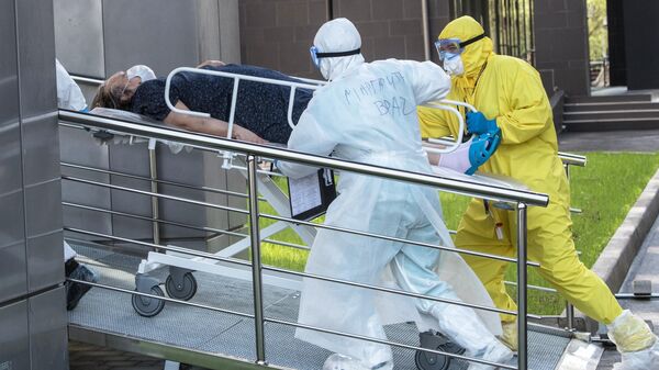 Медики транспортируют пациента с подозрением на коронавирусную инфекцию в приемное отделение национального медицинского центра эндокринологии Минздрава России в Москве