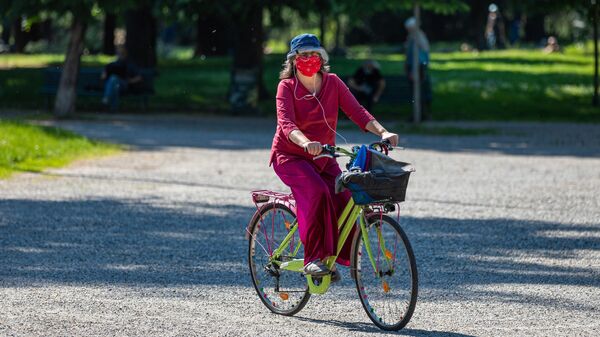 Женщина на велосипеде в одном из парков Милана