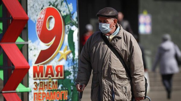 Мужчина проходит мимо украшений ко Дню Победы в Минске, Белоруссия