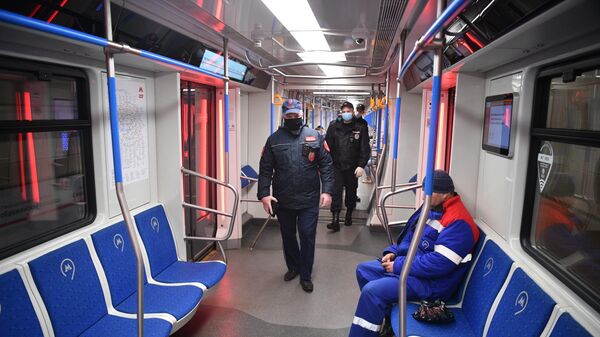 Сотрудники полиции в защитных масках в вагоне московского метро