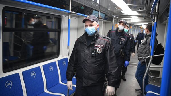 Сотрудники полиции в защитных масках в вагоне московского метро 