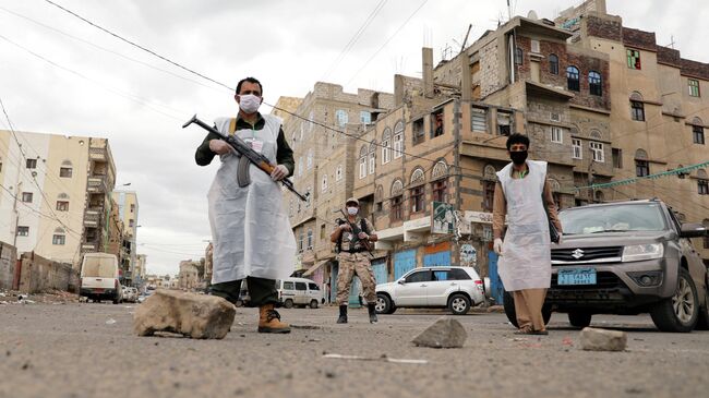 Сотрудники службы безопасности в защитных масках в Сане, Йемен