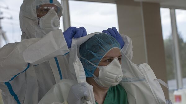 Врачу помогают снять защитный костюм в выходном шлюзе госпиталя для зараженных коронавирусной инфекцией COVID-19 ФКЦ ВМТ ФМБА РФ