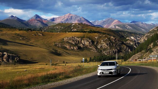 Машина едет по федеральной автомобильной дороге Чуйский тракт в Республике Алтай