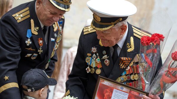 Ветеран Великой Отечественной войны Лука Иванович Кузин принимает поздравления во время персонального парада во дворе своего дома в Севастополе