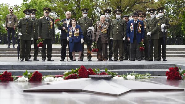 Ветераны Великой Отечественной войны возлагают цветы у Вечного огня в парке Победы во время празднования Дня Победы в Ереване