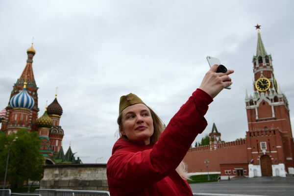 Женщина делает селфи на Красной площади в Москве во время празднования Дня Победы