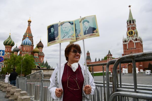 Женщина участвует в акции Бессмертный полк на Красной площади в Москве