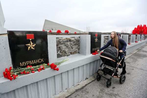 Девушка возлагает цветы к обелиску Города-герои в Мурманске