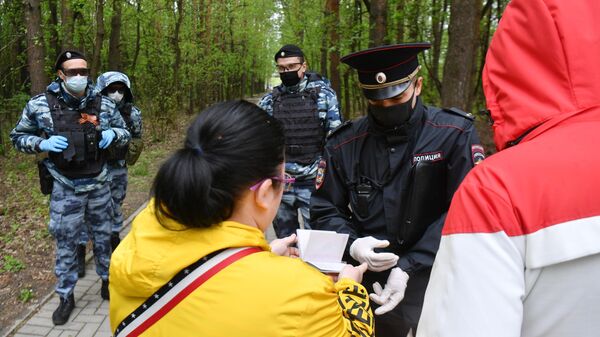 Сотрудник полиции совместно с сотрудниками Росгвардии проверяют документы у прохожих в Москве