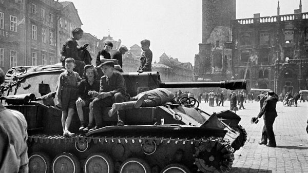 Дети сидят на броне самоходной артиллерийской установки в освобожденной Праге