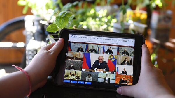 Женщина смотрит трансляцию совещания президента РФ Владимира Путина по ситуации, связанной с распространением коронавируса