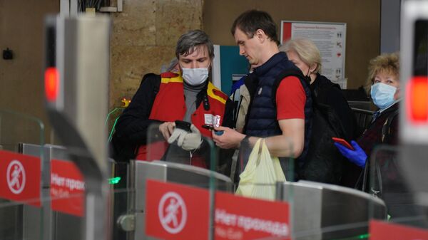 Сотрудник московского метро помогает пассажиру пройти через турникеты
