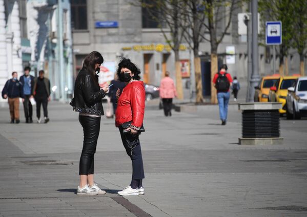 Девушки в медицинских масках на одной из улиц в Москве