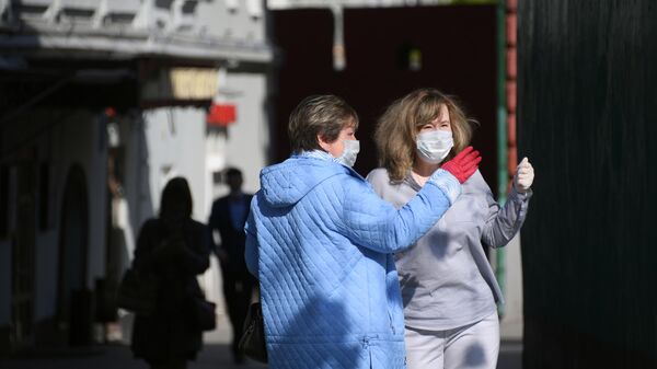 Женщины в медицинских масках и перчатках на одной из улиц в Москве