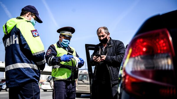 Сотрудники дорожно-патрульной службы ГИБДД во время проверки наличия пропуска у водителя на блокпосту на пересечении Варшавского шоссе с МКАД
