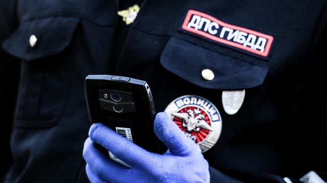 Сотрудник дорожно-патрульной службы ГИБДД во время проверки наличия пропуска у водителя на блокпосту в Москве