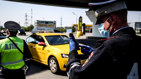 Сотрудники дорожно-патрульной службы ГИБДД во время проверки наличия пропуска у водителя на блокпосту в Москве