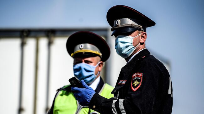 Сотрудники дорожно-патрульной службы ГИБДД во время проверки наличия пропуска у водителя на блокпосту в Москве