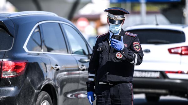 Сотрудник дорожно-патрульной службы ГИБДД в Москве во время проверки пропуска у водителя