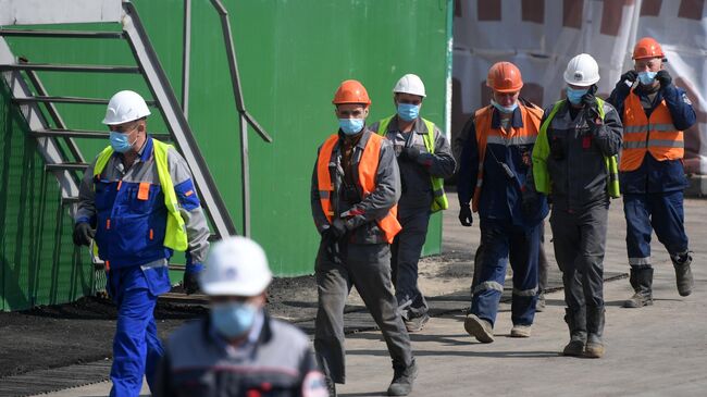 Рабочие в защитных масках во время строительства метро в Москве