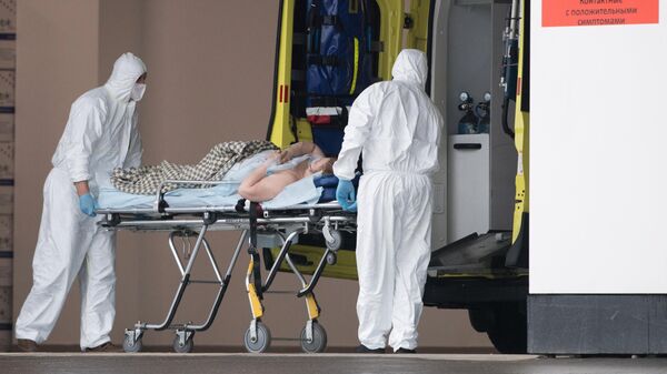 Медики везут на носилках пациента в карантинный центр в Коммунарке