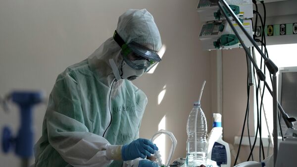 Медицинский работник подключает пациента к аппарату ИВЛ в стационаре для больных с коронавирусной инфекцией на базе Тверской областной клинической больницы