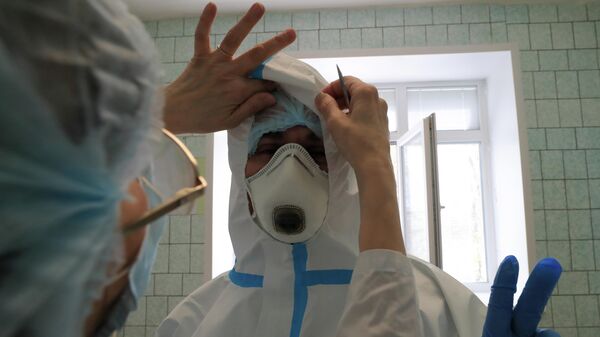 Медицинские работники одевают защитный костюм в стационаре для больных с коронавирусной инфекцией на базе Тверской областной клинической больницы