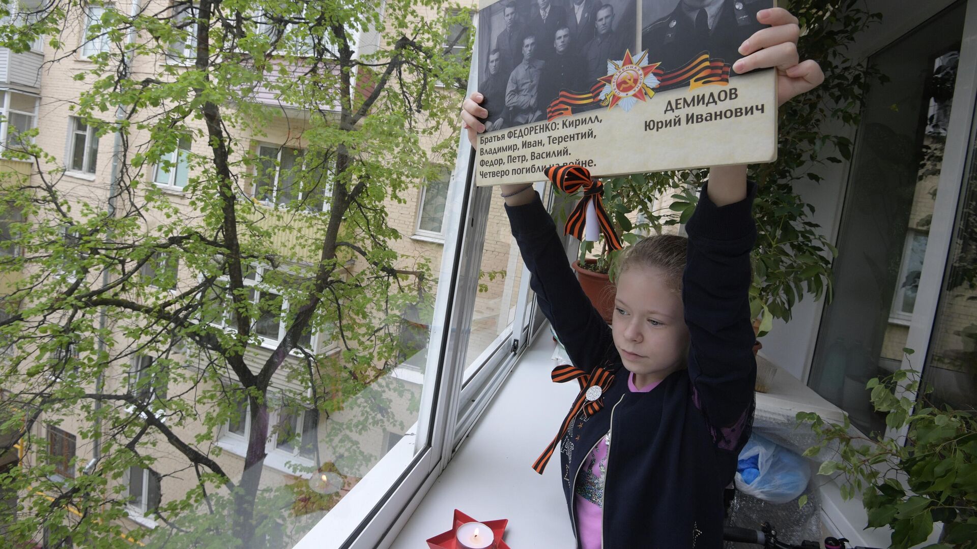 Девочка держит фотографии с портретами своих родственников - ветеранов Великой Отечественной войны - РИА Новости, 1920, 13.05.2020