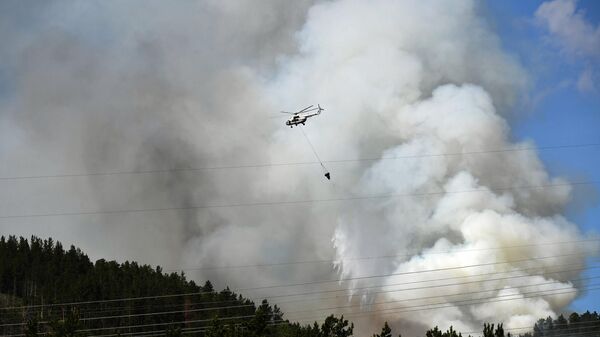 Вертолет Ми-8МБ МЧС России доставляет воду для тушения лесного пожара в тайге в Красноярском крае