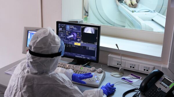 Врач смотрит показания аппарата компьютерной томографии во время обследования пациента в городской клинической больнице имени В. В. Виноградова, переоснащенной для лечения пациентов с  COVID-19