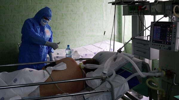  Врач и пациент в отделении реанимации и интенсивной терапии городской клинической больницы имени В. В. Виноградова, переоснащенной для лечения пациентов с COVID-19